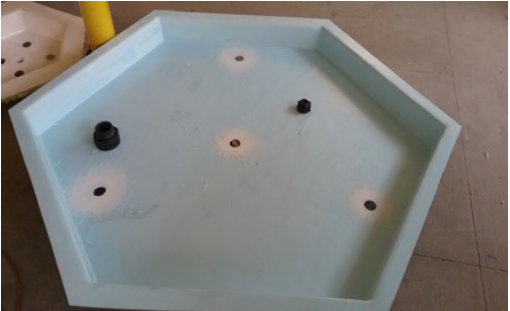 Figure 59: Holes drilled in fiberglass basin to test fit bulkhead fittings.